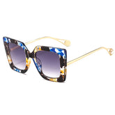 Oversized square sunglasses with gradient lens and gold metal arm detail showcasing bold acetate frame design.