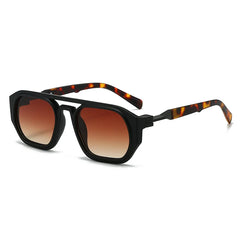 Clear frame sunglasses with pink tinted lens and orange acetate arm detail close up