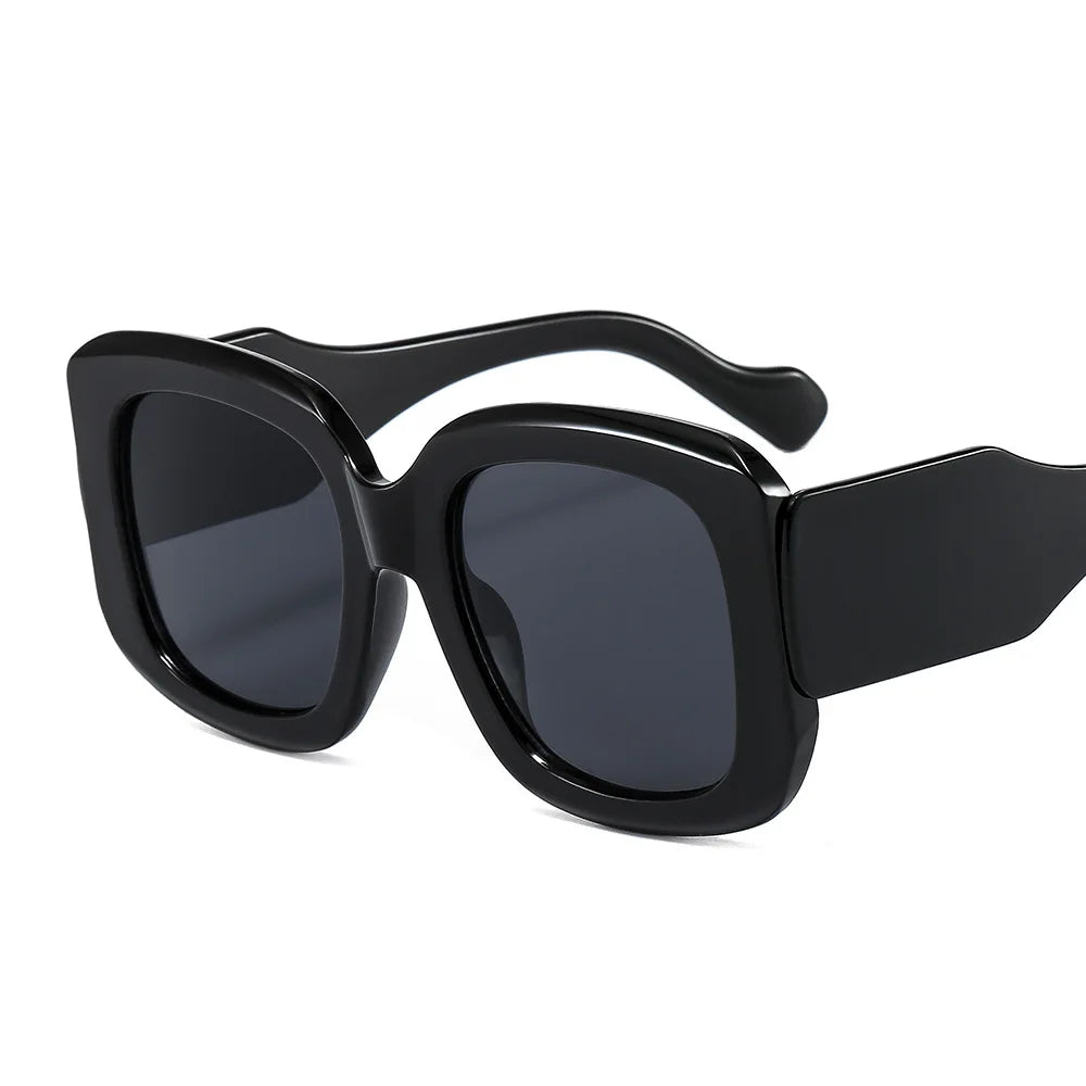 Oversized square frame sunglasses with gradient lens detail showcasing colorful eyewear design and material texture.