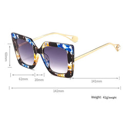 Oversized square sunglasses with gradient lens and gold acetate arm detail close up