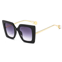 Oversized square sunglasses with gradient lens and gold acetate arm detail close-up