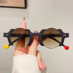 Round frame sunglasses with colorful bubble detail and blue tinted lenses, close up material view