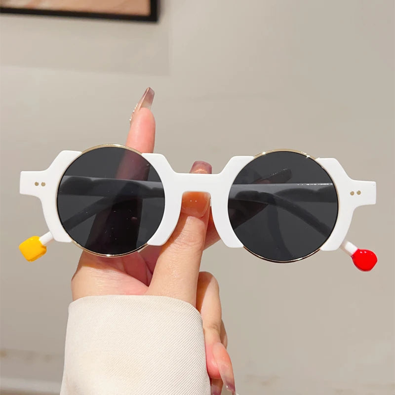 Round frame sunglasses with colorful bubble detail and blue tinted lenses, close-up of frame material and design.